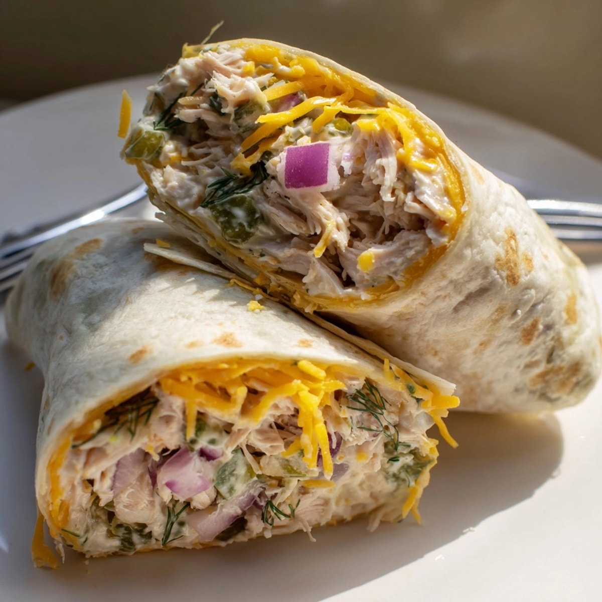 Close-up of a golden Ranch Pickle Chicken Melt Wrap, cheese oozing out.