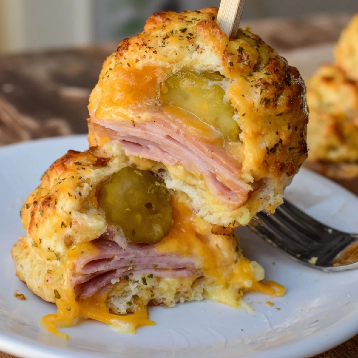 Warm Cheesy Pickle Ham Biscuit Pops on skewers, inviting with melty cheese and tangy pickles.