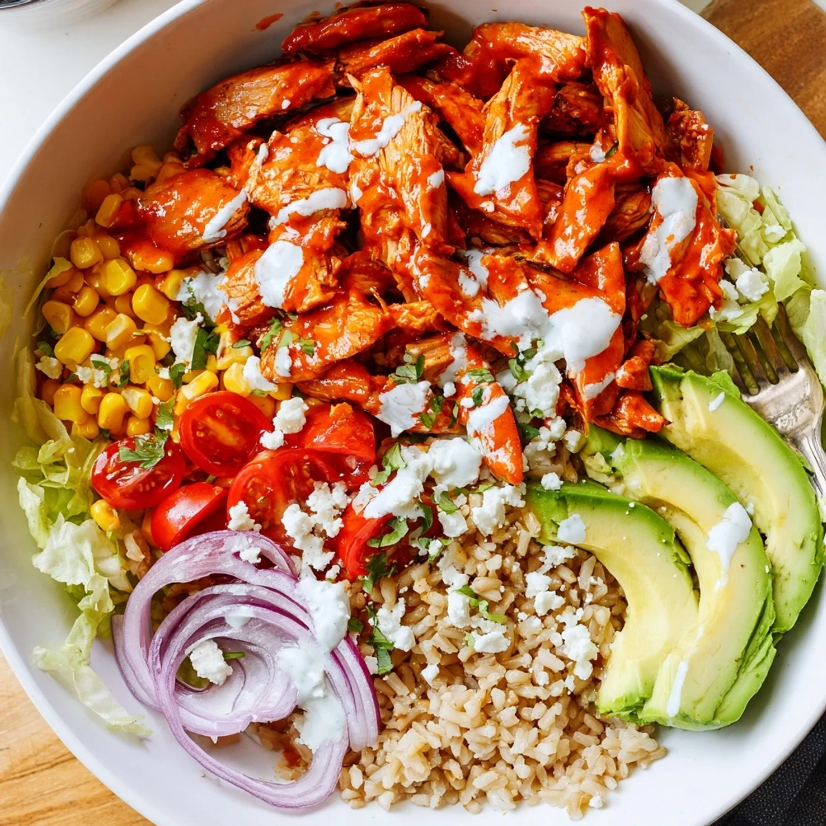 Delicious buffalo chicken bowls topped with colorful veggies and a drizzle of ranch dressing.  