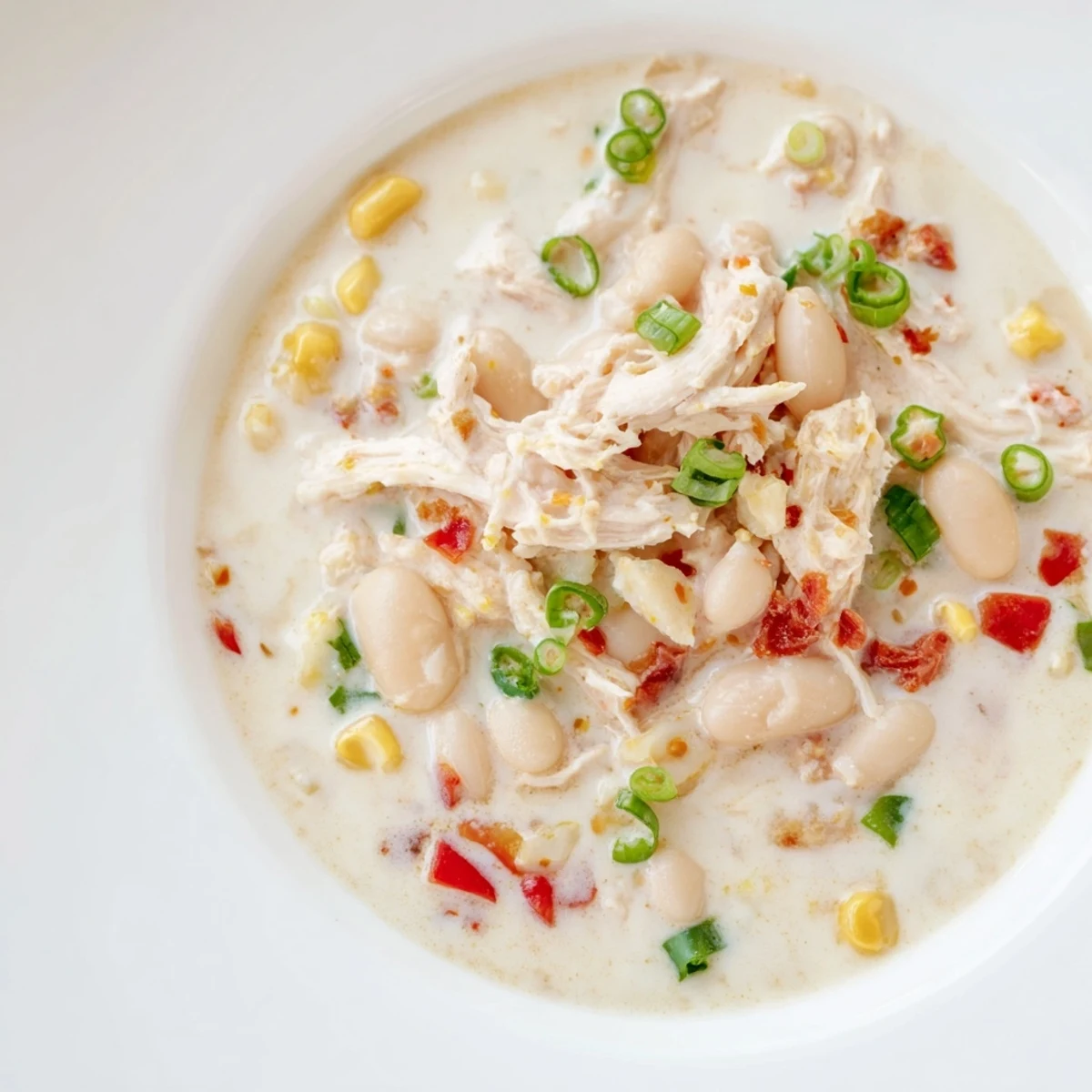 Delicious Creamy White Chicken Chili with Beans, smelling of warm spices, is simmering on the stovetop.