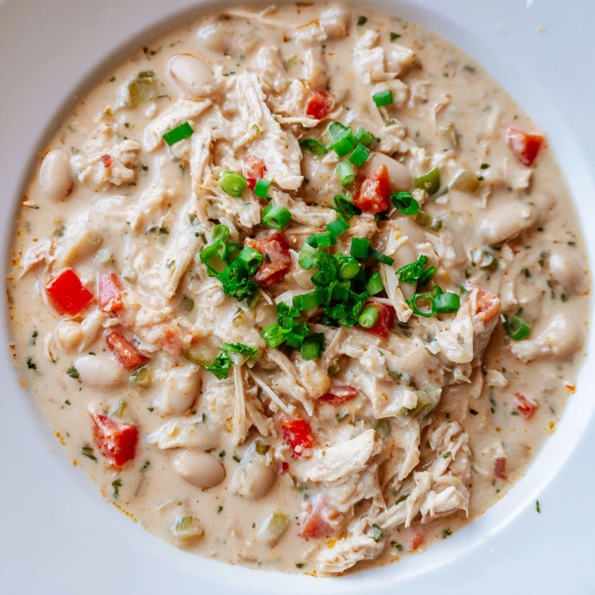 A bowl of Creamy White Chicken Chili with Beans, ready to eat, looks fantastic with lime wedges.