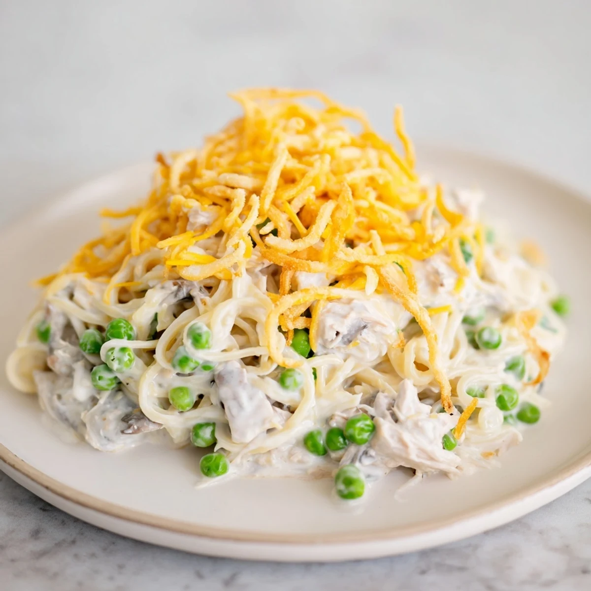Steaming, golden Homemade Tuna Noodle Casserole with a crispy onion topping, perfect for dinner.