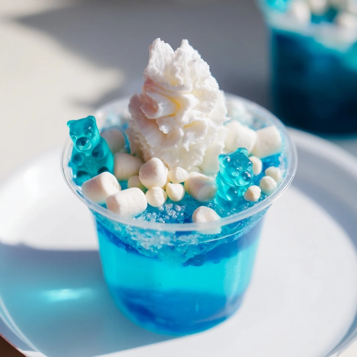 Vibrant snow globe Jello cups, a colorful treat with marshmallows and festive sprinkles, ready to enjoy.