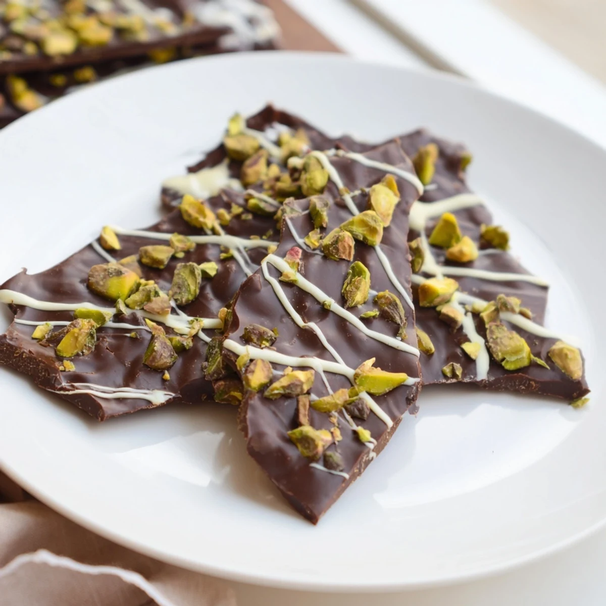 Golden-brown phyllo pastry pieces topping a Pistachio Dubai Chocolate Bark, ready to be broken and served.