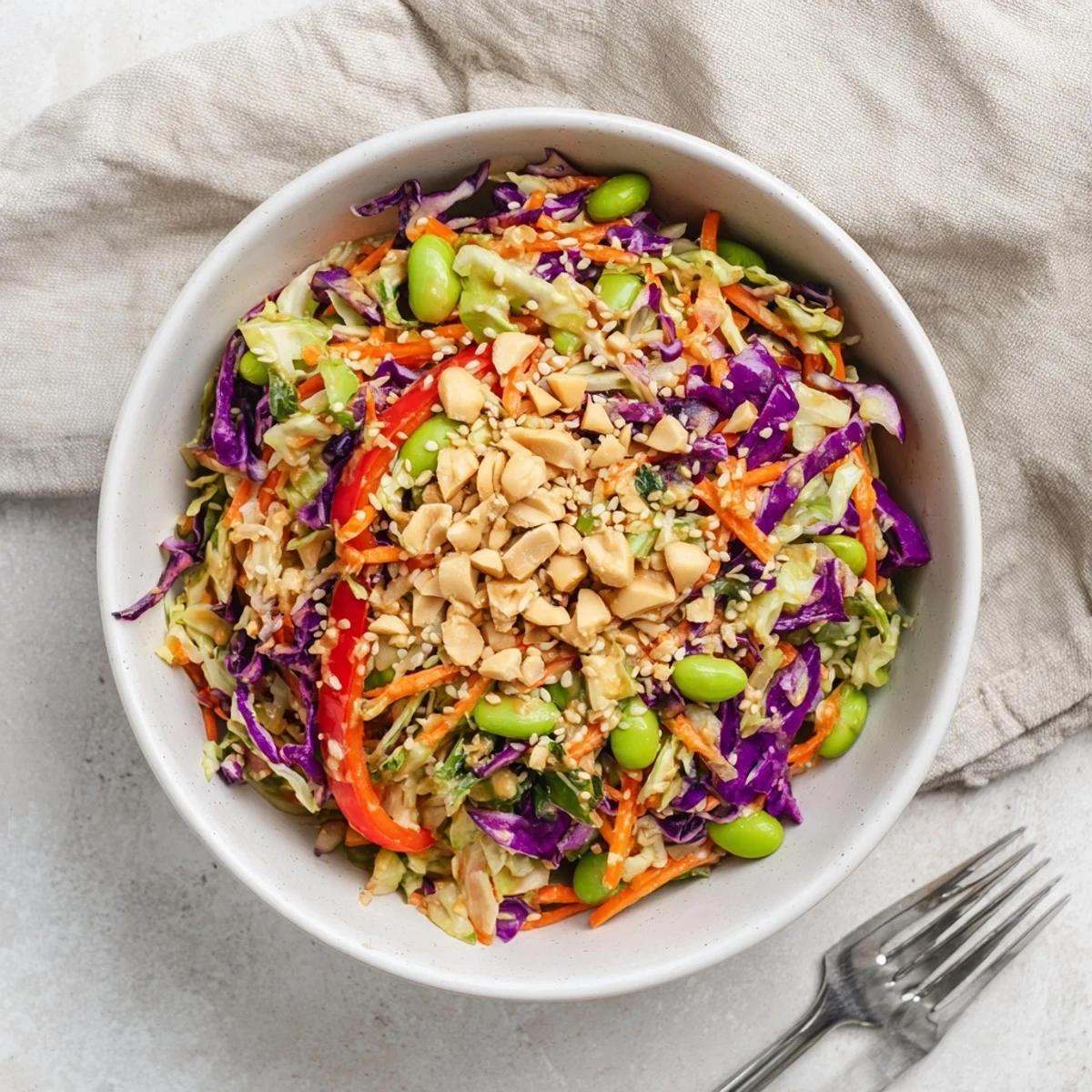 Vibrant Crunchy Thai Peanut Salad featuring shredded cabbage, carrots, and edamame tossed in a creamy peanut dressing.  