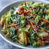Steaming Hot and Sour Cabbage stir-fry with crisp, vibrant green leaves and red chili specks.