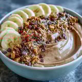 Two healthy Chunky Monkey Smoothie Bowls served with extra toppings on a rustic table.