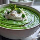 A comforting bowl of Spring Pea Soup topped with creamy ricotta and fresh mint.