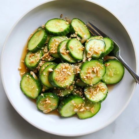 Vibrant Soy Garlic Cucumber Salad: glistening slices in a tangy dressing, sprinkled with sesame seeds.