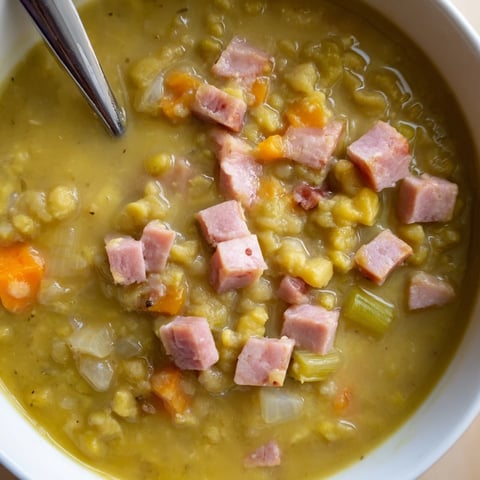 Steaming bowl of Hearty Split Pea and Ham Soup, ready to be served with crusty bread.