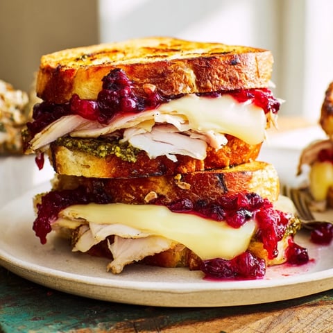 Golden, melty Pesto Cranberry Turkey Grilled Cheese, oozing with cheese and turkey on toasted bread.