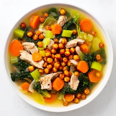 Flavorful Chicken Kale Soup with a vibrant green base, served with a garnish of crispy spiced chickpeas.