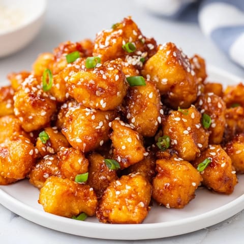 Close-up of freshly fried Honey-Sriracha Chicken Bites, a perfect American-Asian fusion appetizer.