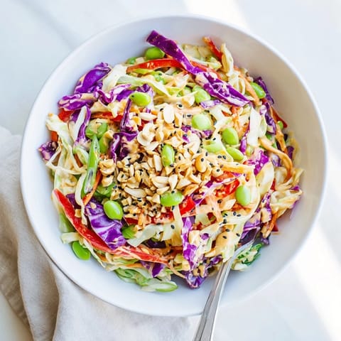A close-up view of Crunchy Thai Peanut Salad topped with chopped peanuts and fresh cilantro, perfect for a light lunch.  