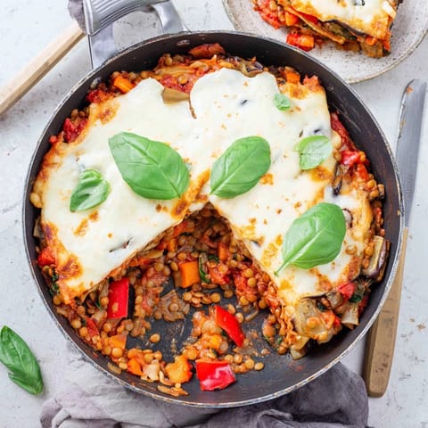 Hearty slices of One-Pan Smoky Veggie Lentil Lasagne reveal layers of smoky lentils, mushrooms, and zucchini in a rich béchamel sauce.