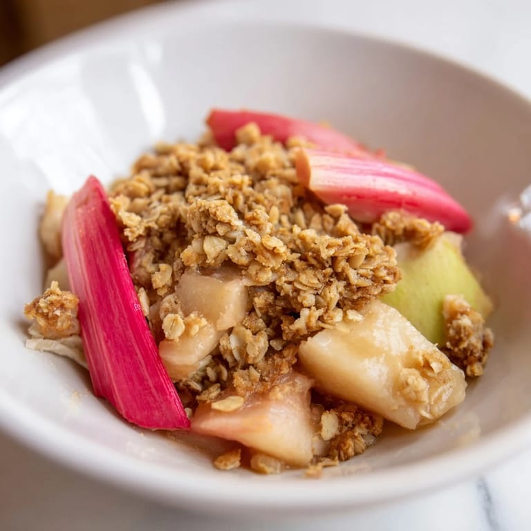 Golden brown apple rhubarb crisp served warm, bursting with sweet and tart flavors.  