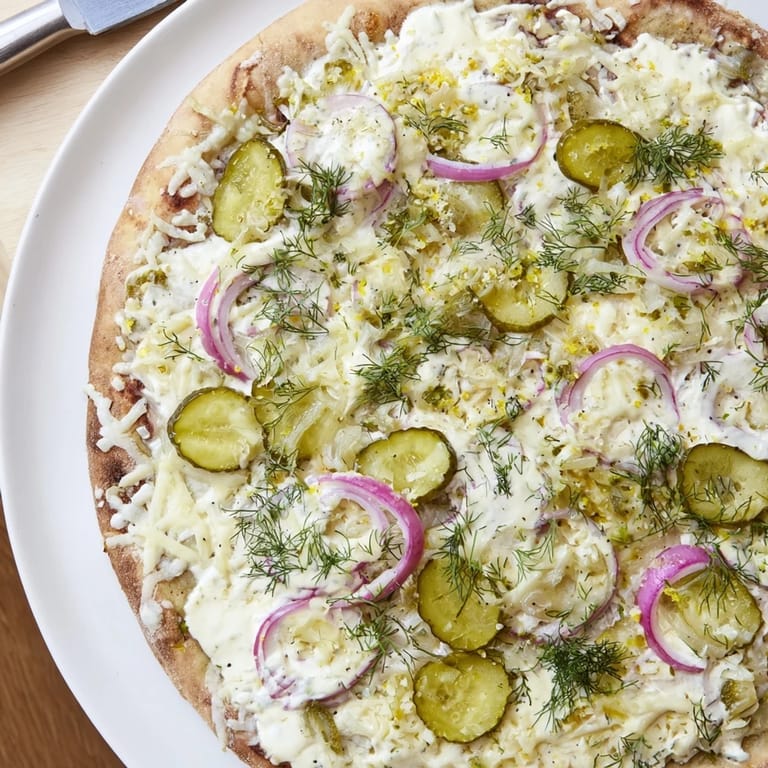Deliciously unique Pickle Pizza garnished with dill and fresh ingredients for extra flavor.  