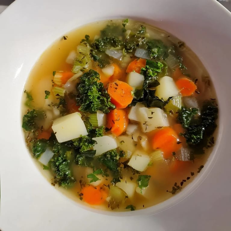 A vibrantly green and rustic bowl of Vegetarian Potato-Kale Soup, with visible potato chunks.