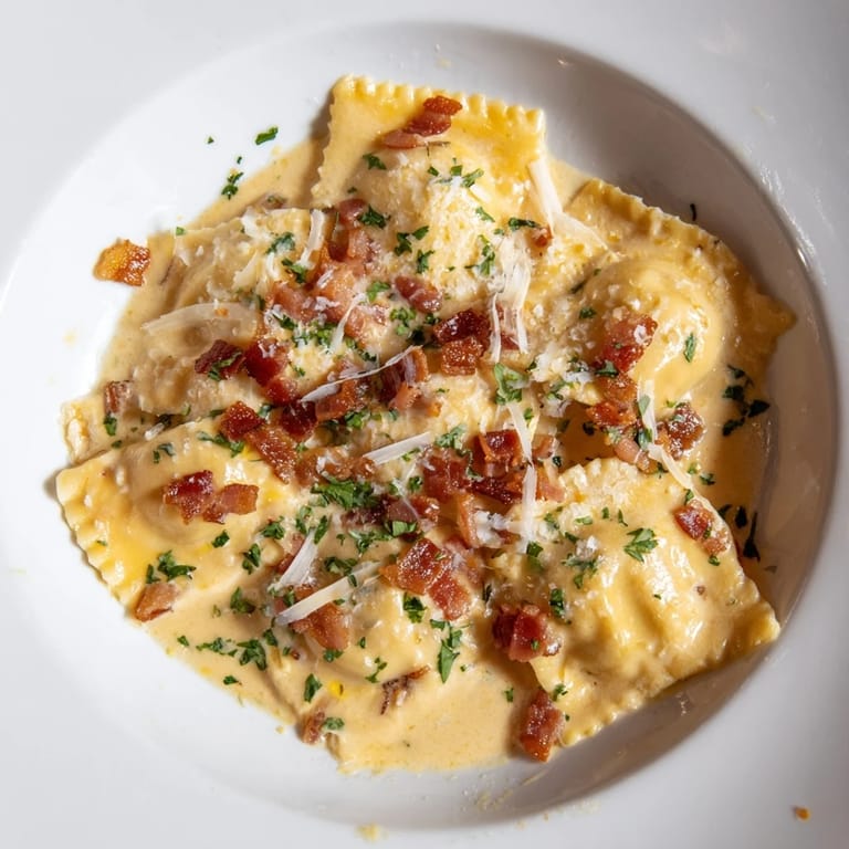 A close-up of delicious Olive Garden Ravioli Carbonara with crispy pancetta and fresh parsley garnish.