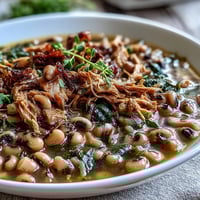 Crock-Pot Black-Eyed Peas with Smoked Turkey are served steaming in a bowl, ready to be paired with fluffy white rice for a Southern comfort meal. 